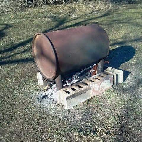 Making biochar with fire pig — 55 gallon drum on cinder blocks at C4 Farms El Dorado Springs Missouri